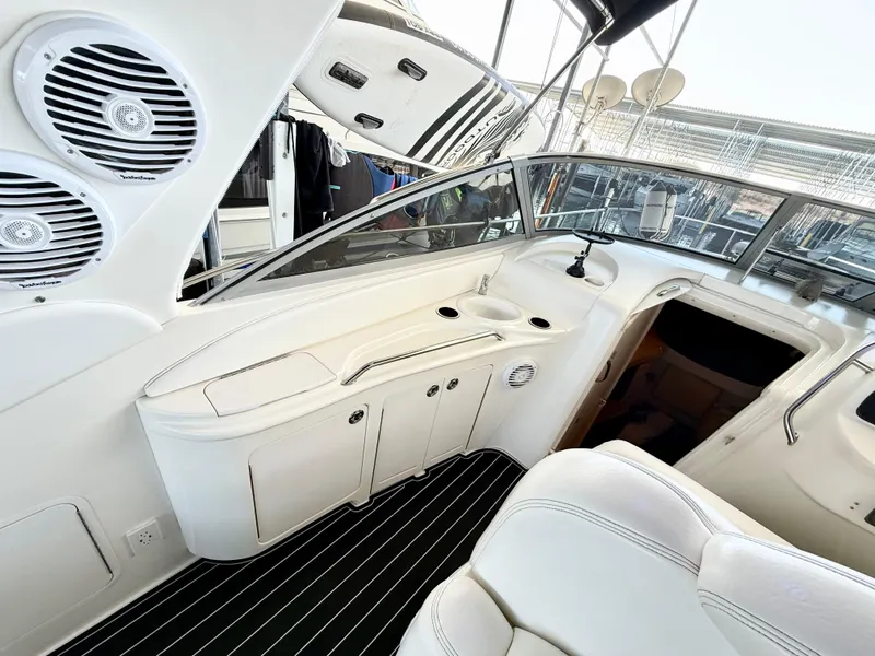 Slide: The Image of 1999 Sea Ray 340 Sundancer cockpit with white seating and sleek dashboard design. - 13