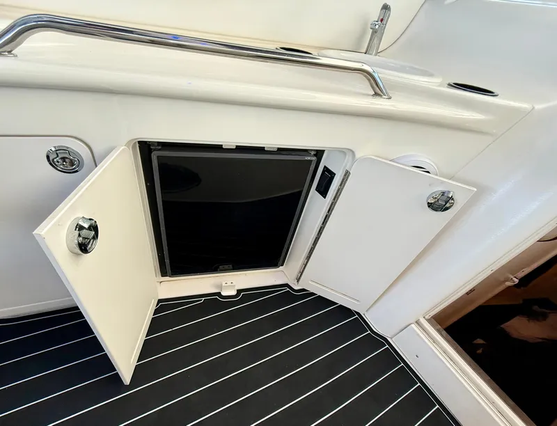 Slide: The Image of 1999 Sea Ray 340 Sundancer interior with open storage compartment and striped flooring. - 14