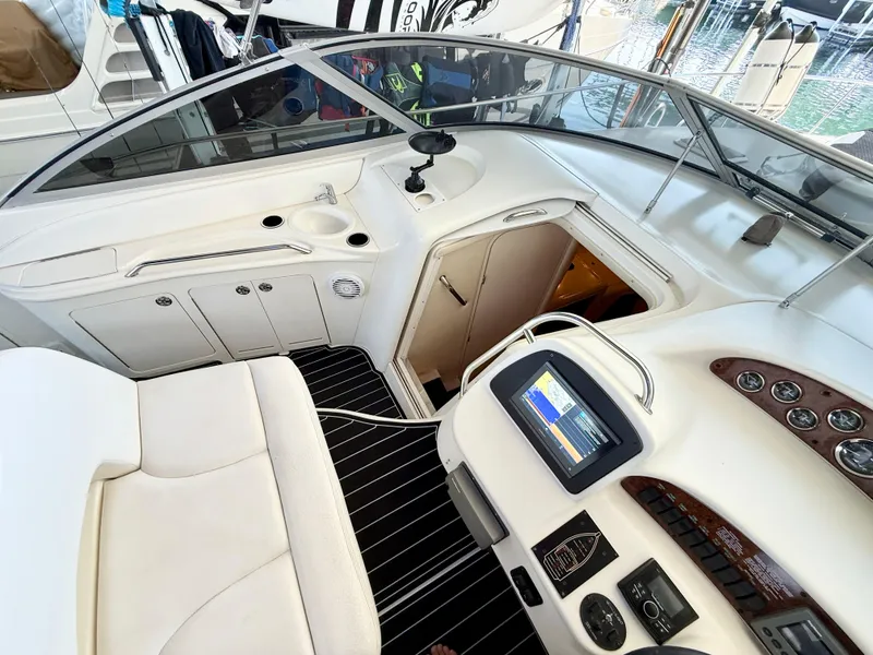 Slide: The Image of 1999 Sea Ray 340 Sundancer cockpit with modern controls and white seating. - 17