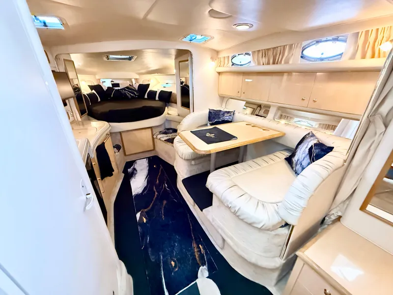 Slide: The Image of Luxurious interior of 1999 Sea Ray 340 Sundancer yacht with elegant seating and dining area. - 18