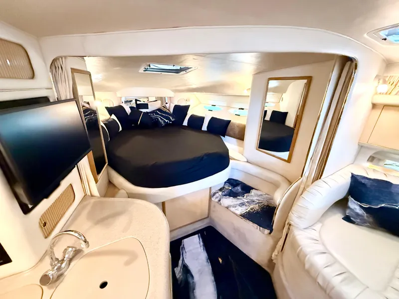Slide: The Image of 1999 Sea Ray 340 Sundancer cabin interior with bed, TV, and seating area. - 20