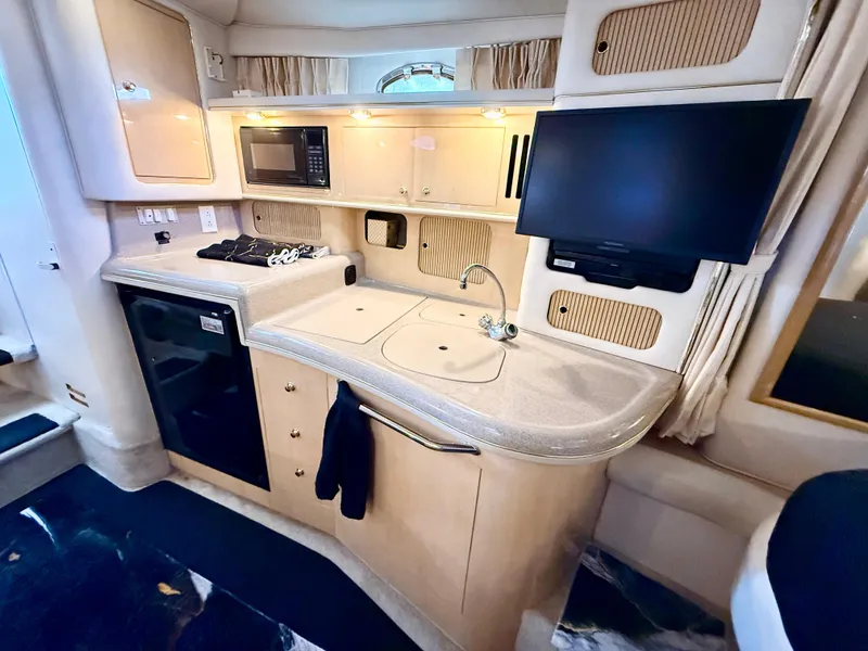 Slide: The Image of 1999 Sea Ray 340 Sundancer interior with kitchenette, microwave, and TV. - 22