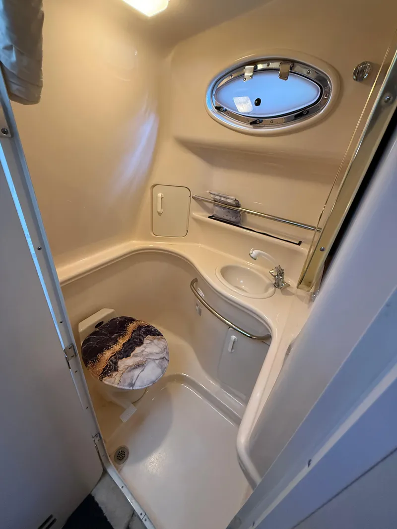 Slide: The Image of 1999 Sea Ray 340 Sundancer bathroom with sink, toilet, and oval window. - 26