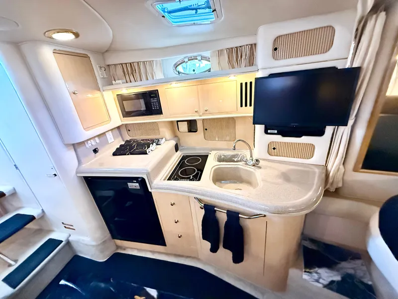Slide: The Image of Interior of 1999 Sea Ray 340 Sundancer yacht with kitchenette and modern amenities. - 28