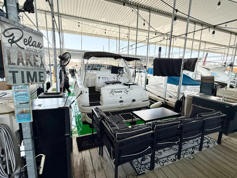 Slide: The Image of 1999 Sea Ray 340 Sundancer docked with outdoor seating and "Lake Time" sign. - 3