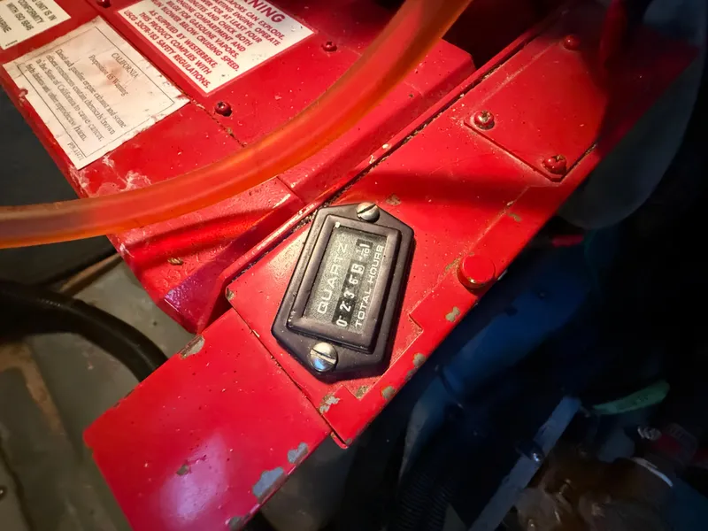 Slide: The Image of Engine compartment of 1999 Sea Ray 340 Sundancer with red machinery and warning labels. - 39