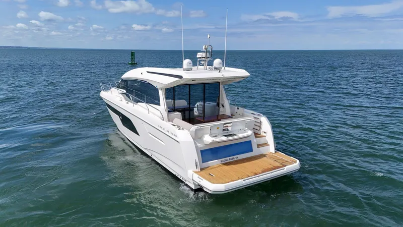 Slide: The Image of 2019 Prestige 520S yacht cruising on open water under a clear blue sky. - 14