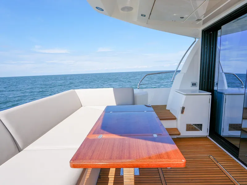 Slide: The Image of 2019 Prestige 520S yacht deck with seating, wooden table, and ocean view. - 41