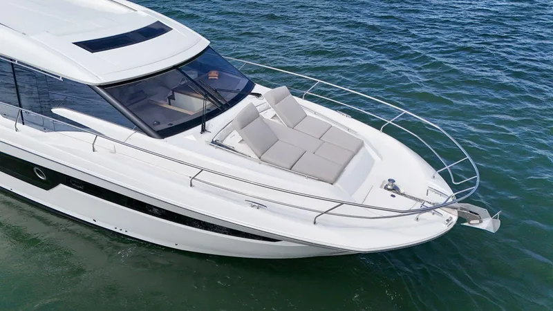 Slide: The Image of 2019 Prestige 520S yacht cruising on clear blue water, featuring sleek design and sunbathing area. - 45