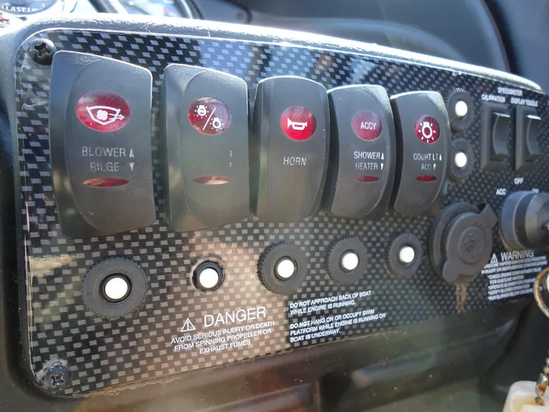 Slide: The Image of Control panel of a 2009 Calabria Pro V II boat with various switches and warnings. - 12