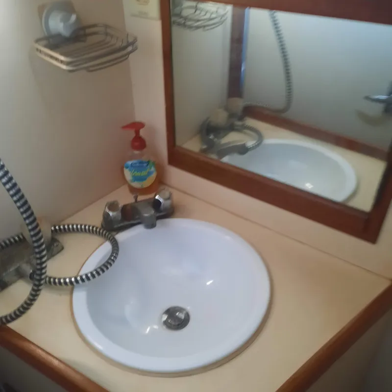 Slide: The Image of Bathroom sink area on a 1984 Cheoy Lee Sloop yacht with mirror and soap. - 10