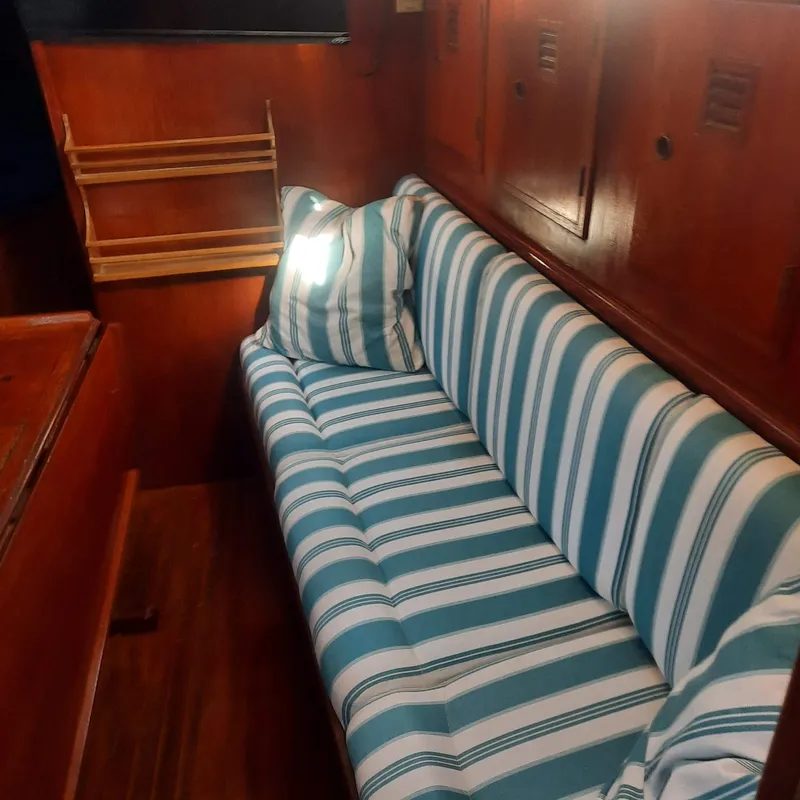Slide: The Image of Interior of 1984 Cheoy Lee Sloop with striped blue and white seating. - 11