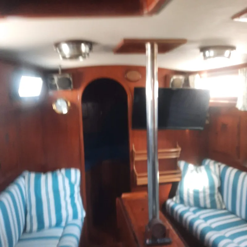 Slide: The Image of Interior of 1984 Cheoy Lee Sloop with striped seating and wooden finishes. - 12
