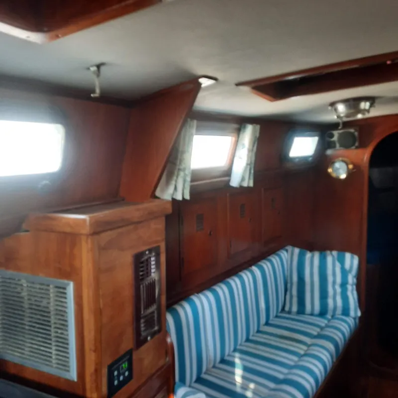 Slide: The Image of Interior of 1984 Cheoy Lee Sloop with striped seating and wooden cabinetry. - 13