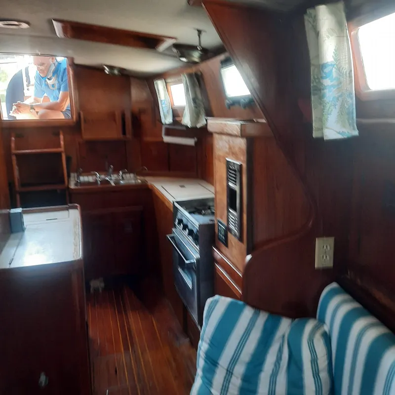 Slide: The Image of Interior of 1984 Cheoy Lee Sloop with wooden cabinetry and striped cushions. - 15