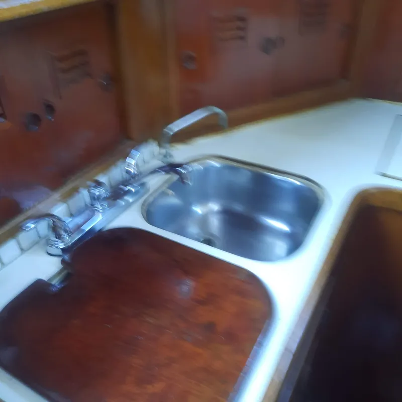 Slide: The Image of 1984 Cheoy Lee Sloop kitchen with sink and wooden cabinetry. - 17