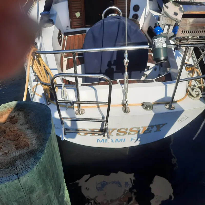Slide: The Image of 1984 Cheoy Lee Sloop docked, rear view with ladder and equipment visible. - 5