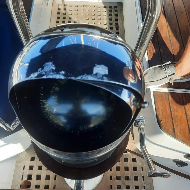 Slide: The Image of Compass on 1984 Cheoy Lee Sloop yacht, reflecting sunlight on wooden deck. - 8