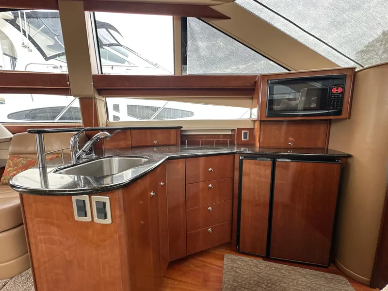 Slide: The Image of Luxurious 2008 Meridian 391 Sedan yacht kitchen with wood cabinetry, sink, microwave, and mini fridge. - 27