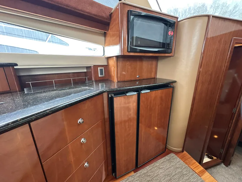 Slide: The Image of 2008 Meridian 391 Sedan yacht interior with wood cabinetry, microwave, and compact refrigerator. - 29