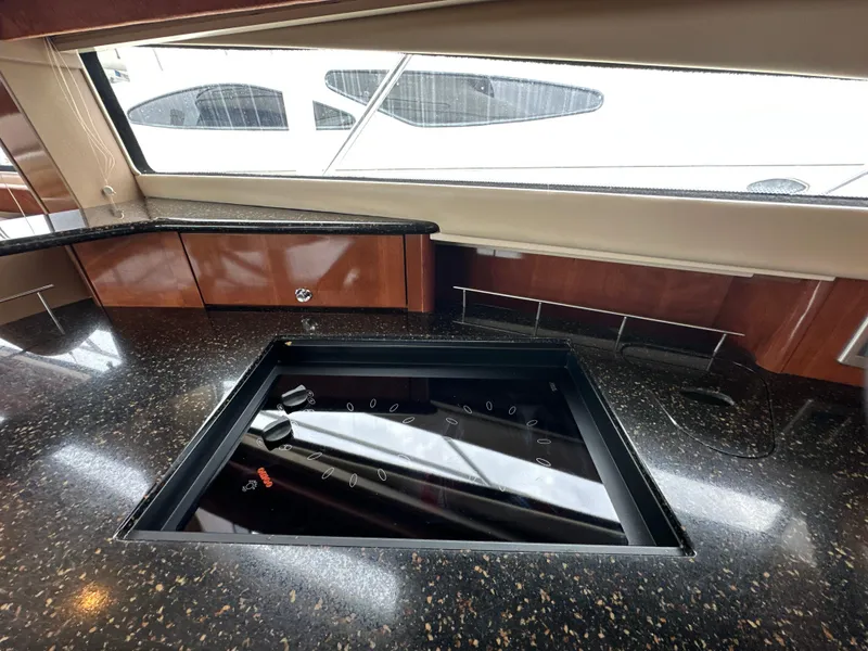 Slide: The Image of Luxurious 2008 Meridian 391 Sedan yacht kitchen with sleek black countertop and modern stove. - 30