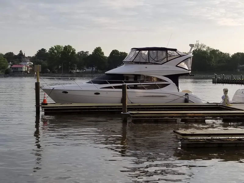 Slide: The Image of 2008 Meridian 391 Sedan yacht docked on a calm lake with trees in the background. - 5