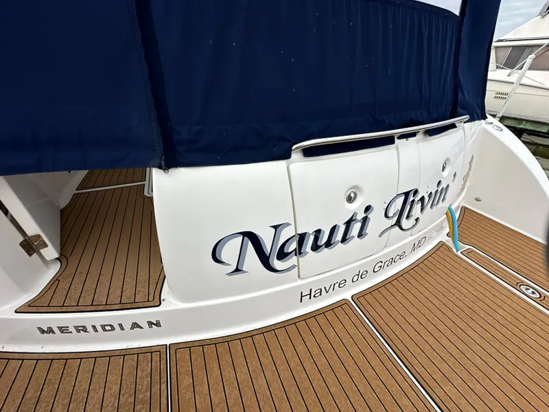 Slide: The Image of 2008 Meridian 391 Sedan yacht with "Nauti Livin" name, docked with wooden deck. - 8