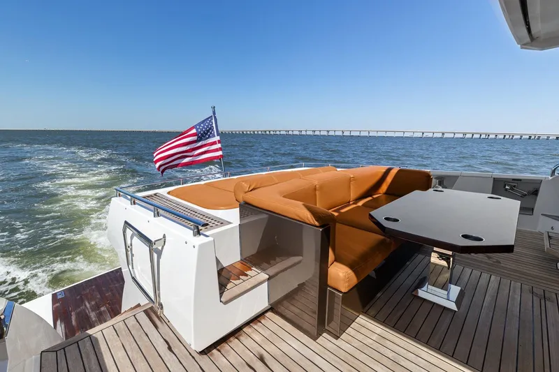 Slide: The Image of 2013 Cheoy Lee 76 Alpha yacht deck with seating, table, and American flag. - 29