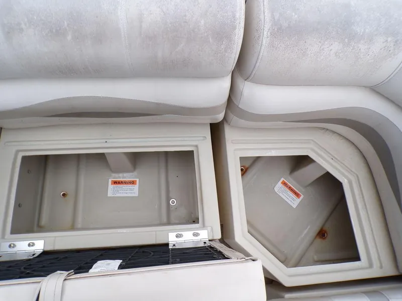 Slide: The Image of Crest II DL 2000 boat storage compartments with warning labels, open and empty. - 11
