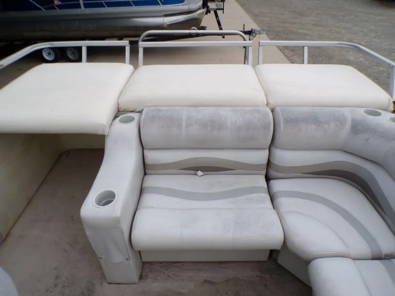 Slide: The Image of Crest II DL 2000 boat seating with white and gray upholstery, featuring cup holders. - 12