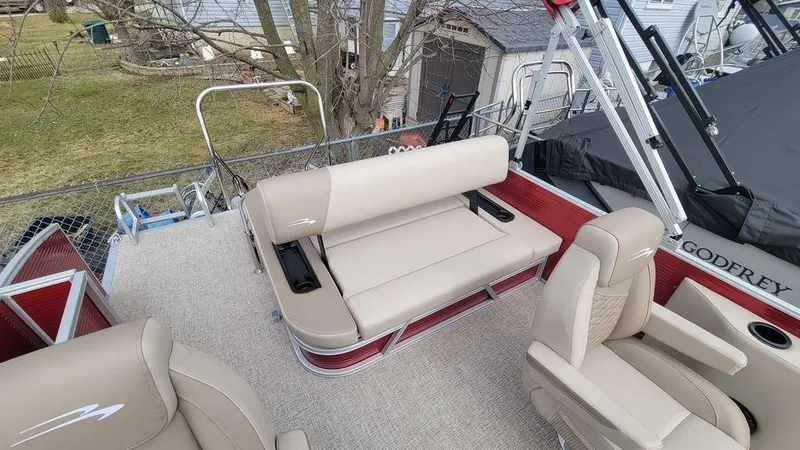 Slide: The Image of 2025 Bennington S Swingback 22 SSB pontoon boat with beige seating and red accents. - 10