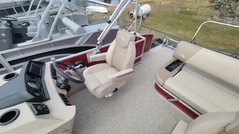 Slide: The Image of 2025 Bennington S Swingback 22 SSB pontoon boat interior with beige seating and modern helm. - 5