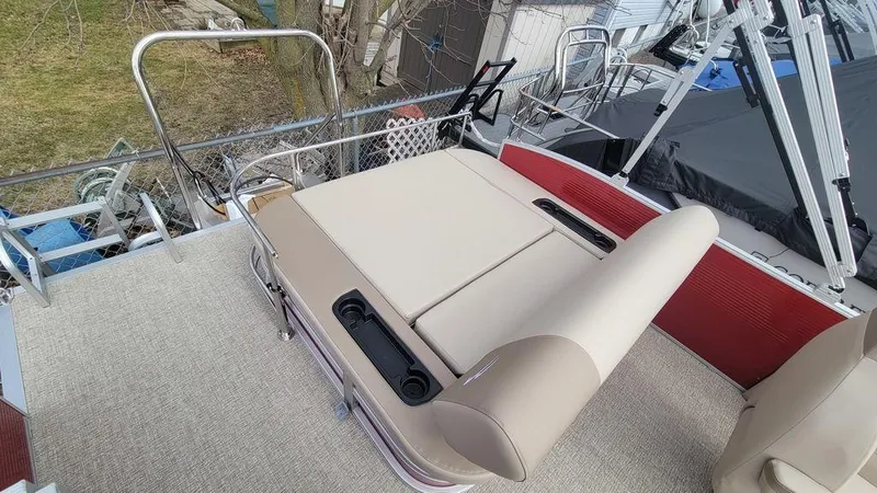 Slide: The Image of 2025 Bennington S Swingback 22 SSB pontoon boat with beige seating and red accents. - 9