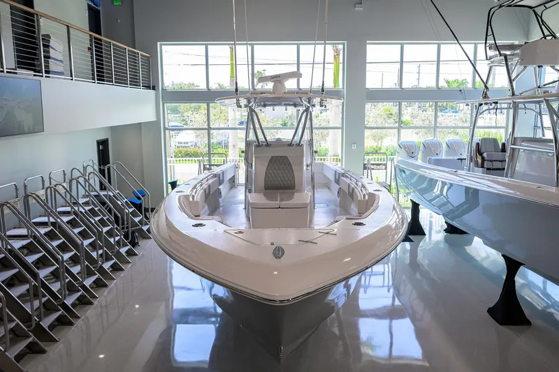 Slide: The Image of 2025 Contender 39 ST boat displayed in a modern showroom with large windows. - 1