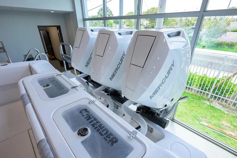 Slide: The Image of 2025 Contender 39 ST boat with triple Mercury outboard engines in showroom. - 48