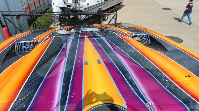 Slide: The Image of Vibrant 2010 MTI 48 R/P boat with colorful stripes and carbon fiber accents. - 14