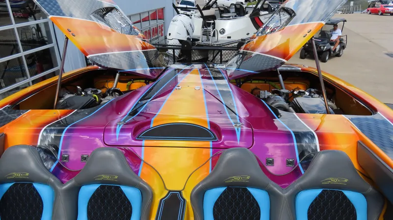 Slide: The Image of Vibrant 2010 MTI 48 R/P speedboat with colorful custom paint and open engine hatches. - 20
