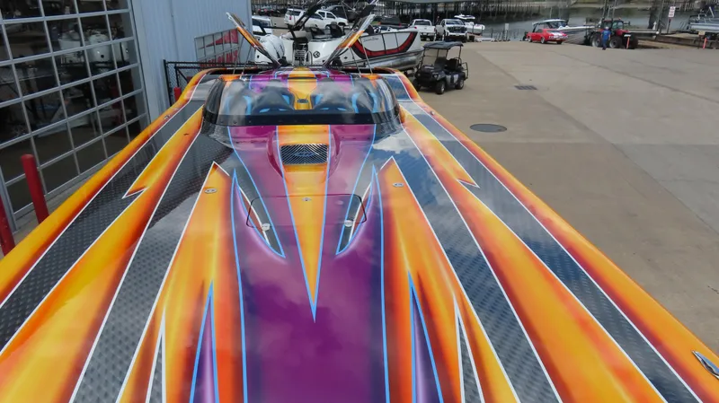 Slide: The Image of Vibrant 2010 MTI 48 R/P speedboat with colorful custom paint at a marina. - 30