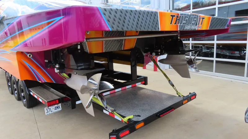 Slide: The Image of 2010 MTI 48 R/P speedboat with vibrant colors and dual propellers on a trailer. - 31