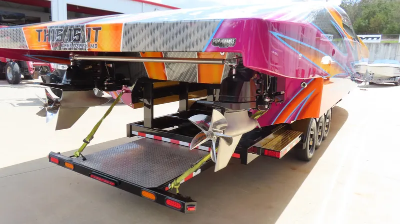 Slide: The Image of 2010 MTI 48 R/P powerboat on trailer, vibrant colors, dual propellers, rear view. - 35