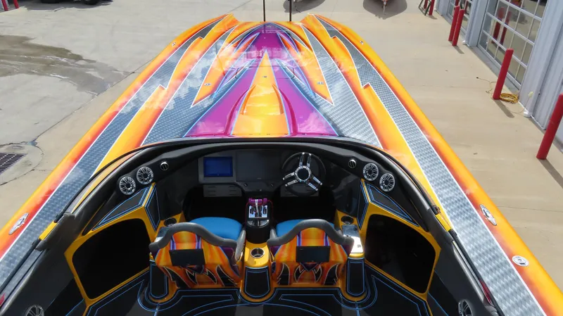 Slide: The Image of Vibrant 2010 MTI 48 R/P speedboat with colorful custom paint and sleek cockpit design. - 7