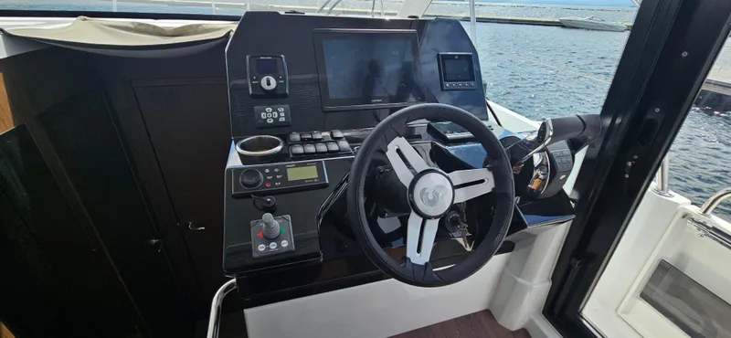 Slide: The Image of Cockpit of 2022 Beneteau Antares 11 with steering wheel and navigation controls. - 11