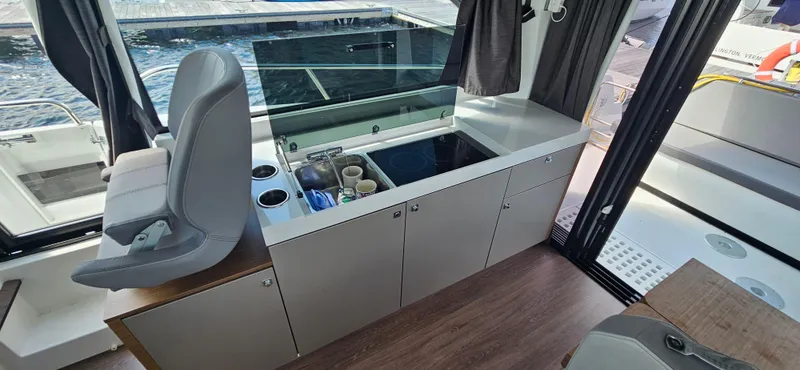 Slide: The Image of Interior of 2022 Beneteau Antares 11 boat with modern kitchenette and seating. - 14