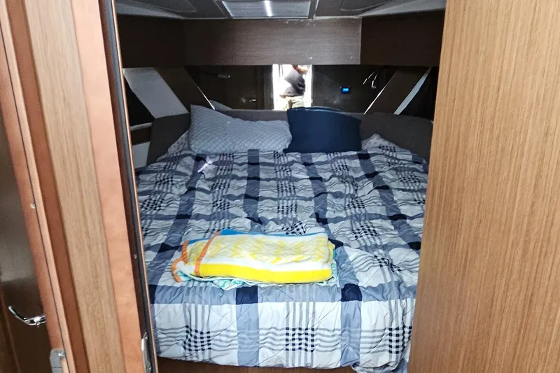 Slide: The Image of Cozy cabin interior of 2022 Beneteau Antares 11 with plaid bedding and wooden accents. - 17