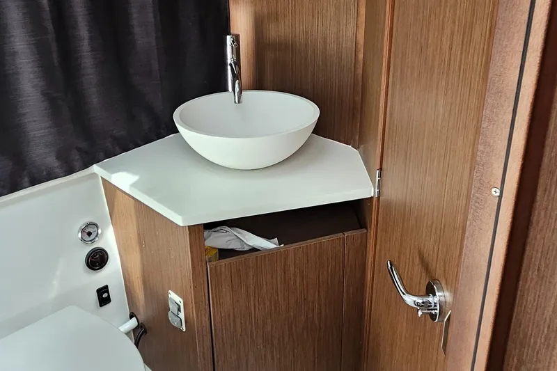 Slide: The Image of Modern bathroom sink in 2022 Beneteau Antares 11 boat, featuring wood cabinetry and sleek design. - 18