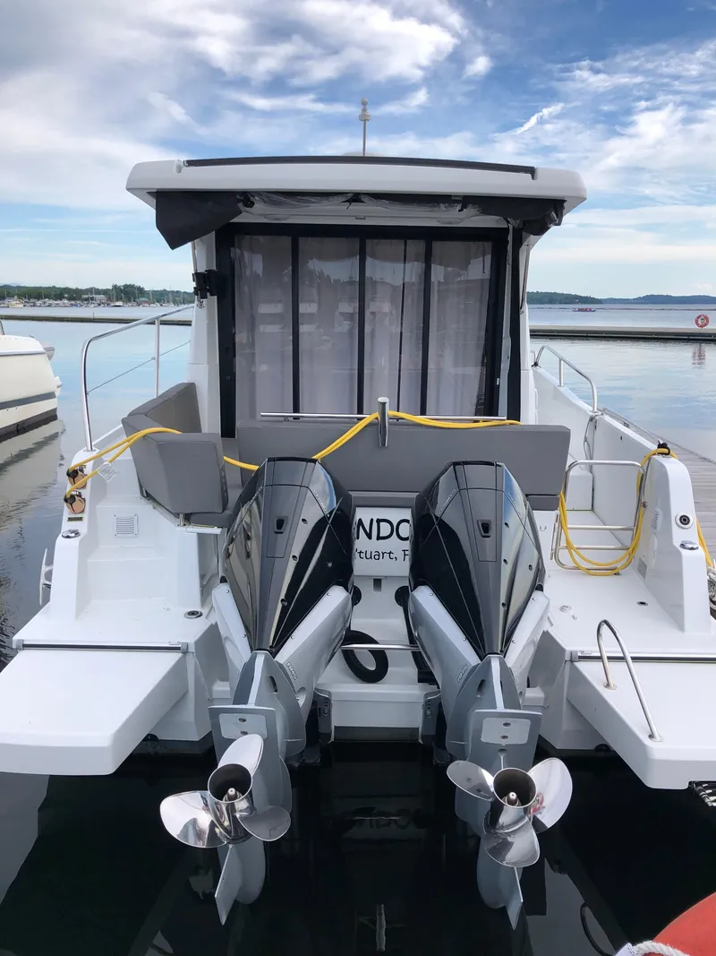 Slide: The Image of 2022 Beneteau Antares 11 with dual outboard motors docked at a marina. - 3