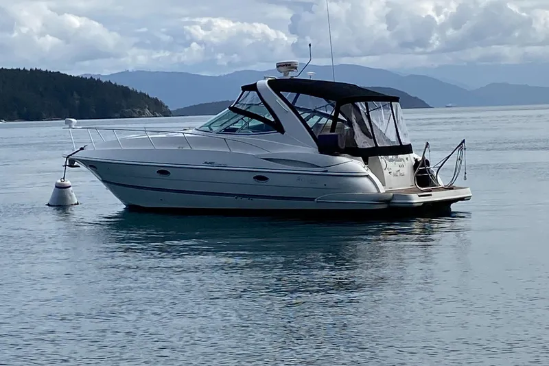 The Image of 2007 Cruisers Yachts 340 Express boat on calm water with scenic mountain backdrop. - 0