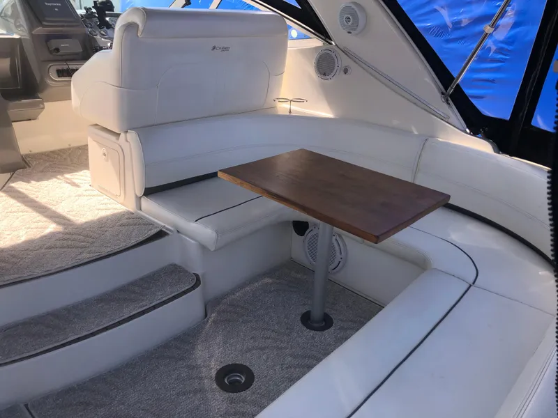 Slide: The Image of 2007 Cruisers Yachts 340 Express interior with white seating and wooden table. - 12