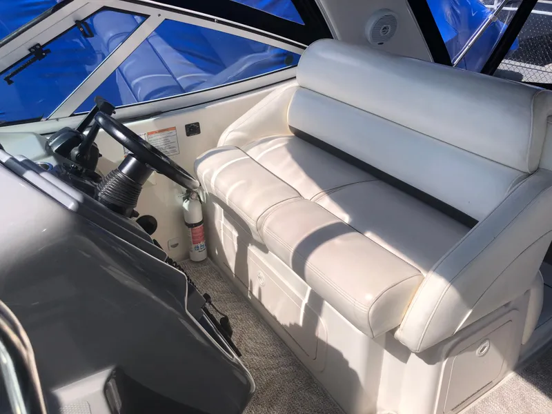 Slide: The Image of 2007 Cruisers Yachts 340 Express helm with white leather seating and steering wheel. - 19