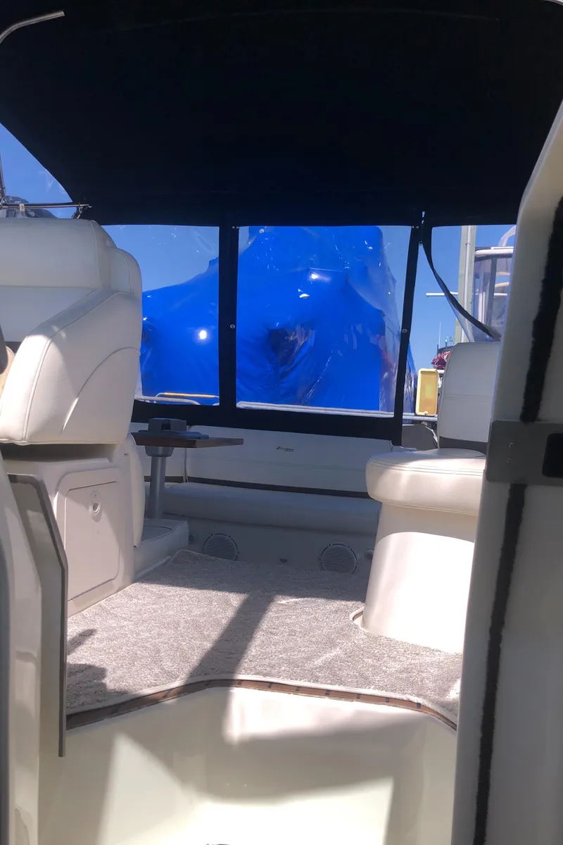 Slide: The Image of Interior view of 2007 Cruisers Yachts 340 Express, featuring white seating and carpeted flooring. - 26